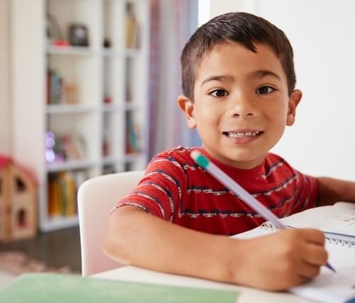 child doing homework looking at camera